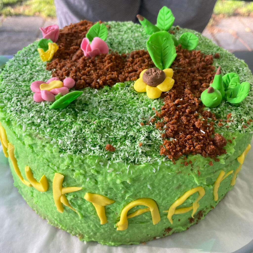 Groene Plukroute taart met bruine en groene bomen en gele bloemen