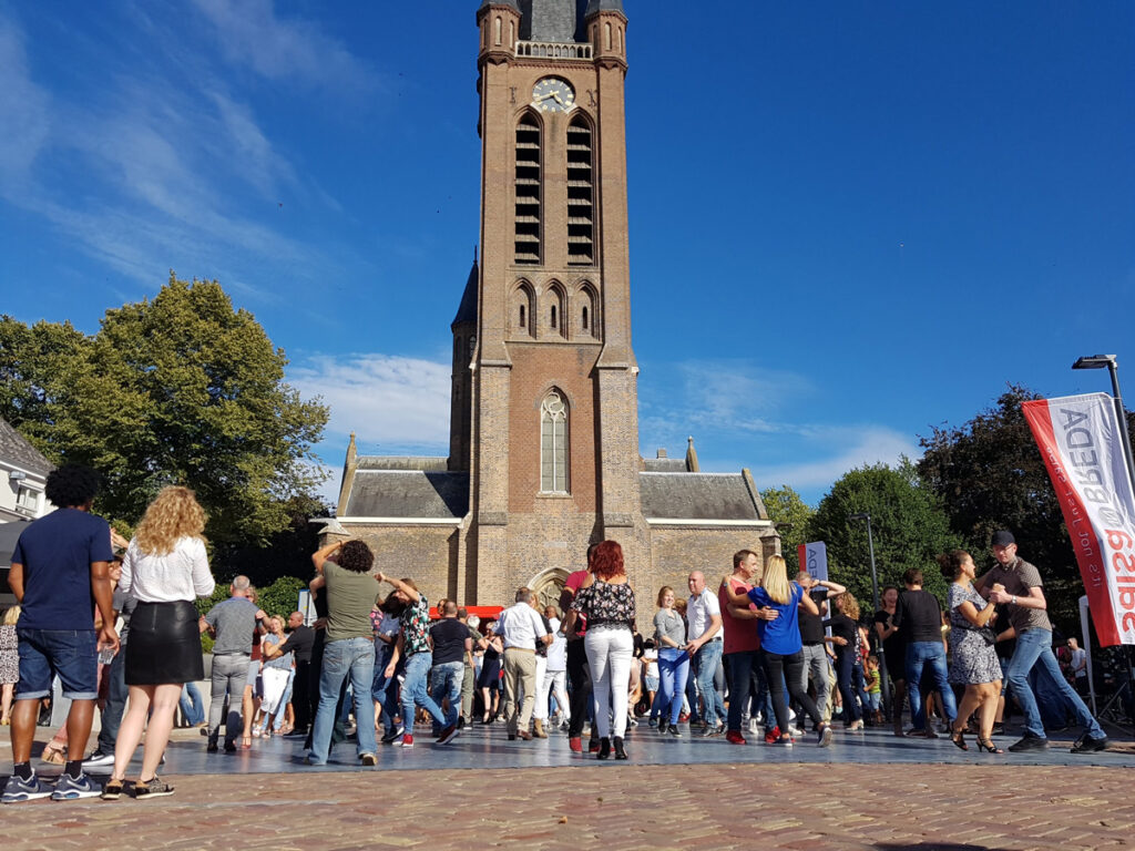 Koppels dansen salsa op het plein voor de Snt Martinuskerk