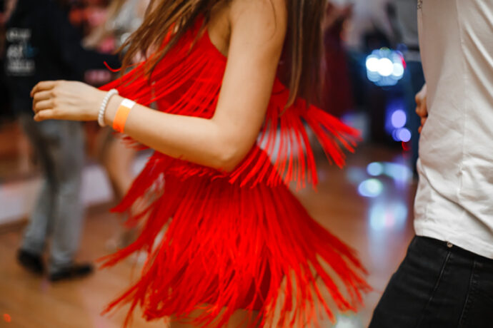 vrouw met rode jurk danst salsa