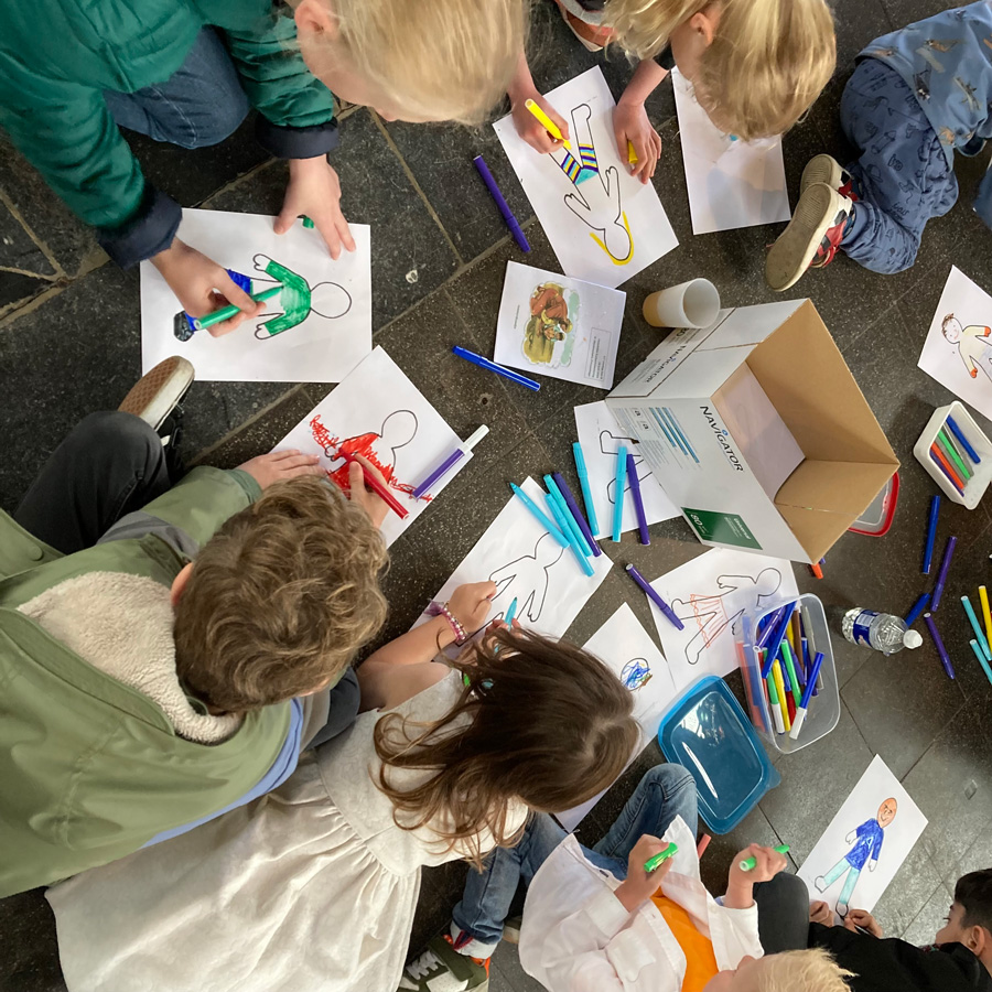 Kinderen kleuren in een poppetje in