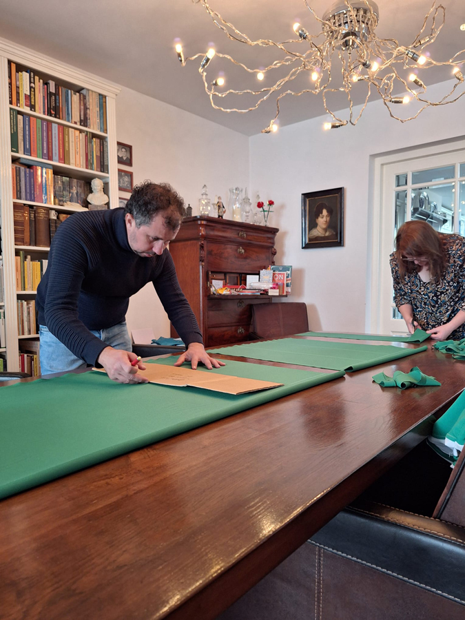 Man knipt groene stof voor de vlag van Princenhage