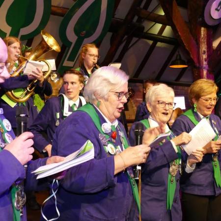 Groep personen in een boerenkiel zingt carnavalsliedjes