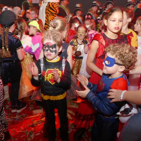 zaal vol met verklede, carnavalsvierdende kinderen