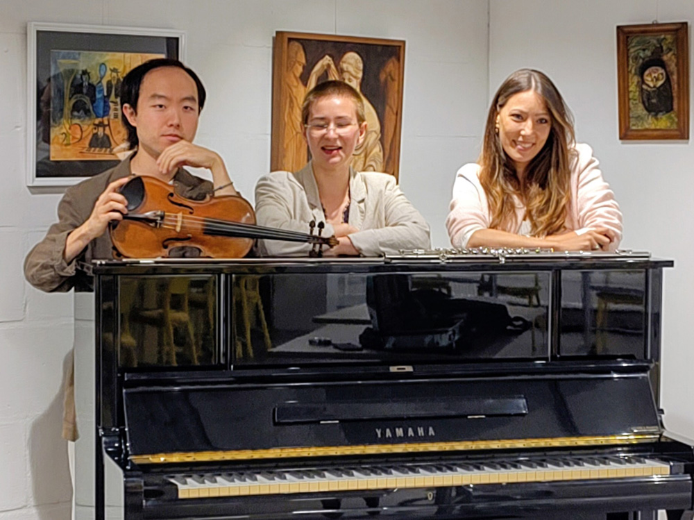 Muzikanten Joshua Park, Diana Pivak en Dušica Nikolić staan achter een piano
