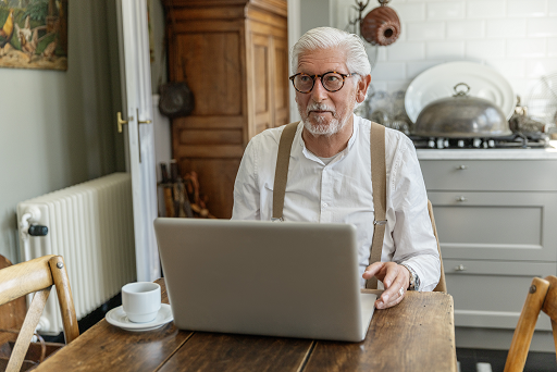 senior achter een laptop