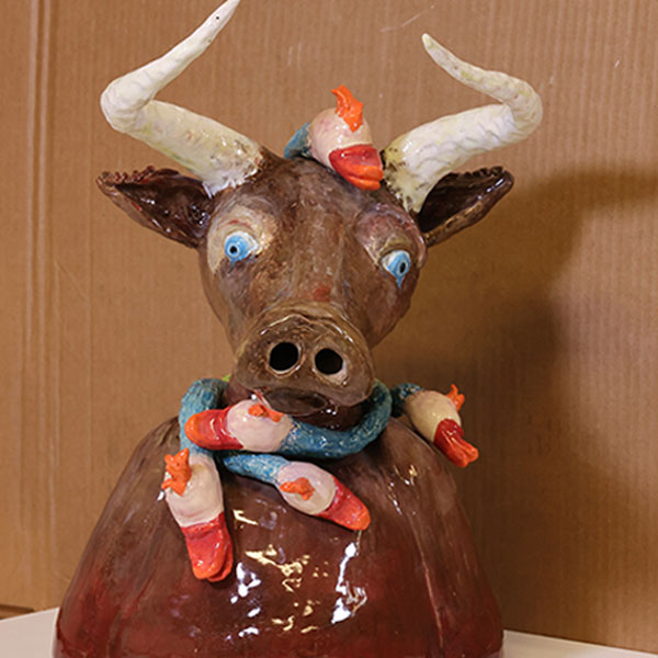 een keramiek beeldje in de vorm van een koe met hoorns