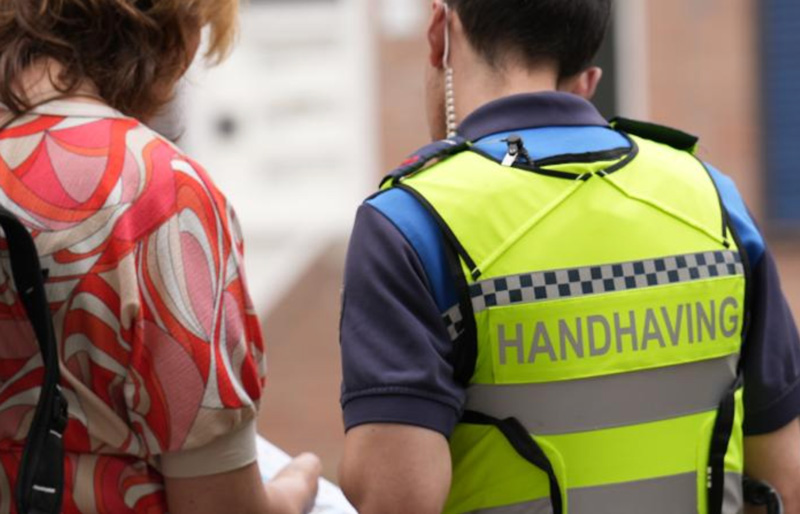 handhaver helpt bewoner