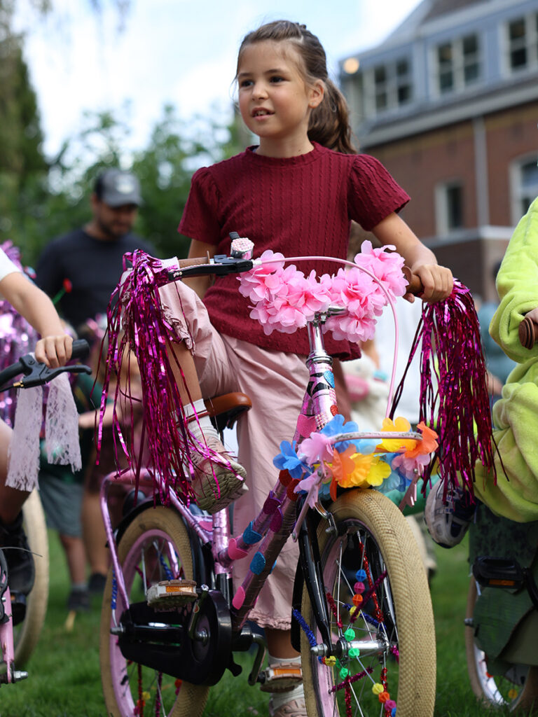 Meisje met een fiets versierd met bloemen