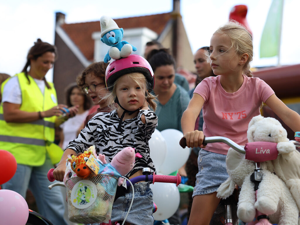 Twee meisjes. Een meisje heeft een bluwe smurf op haar helm.