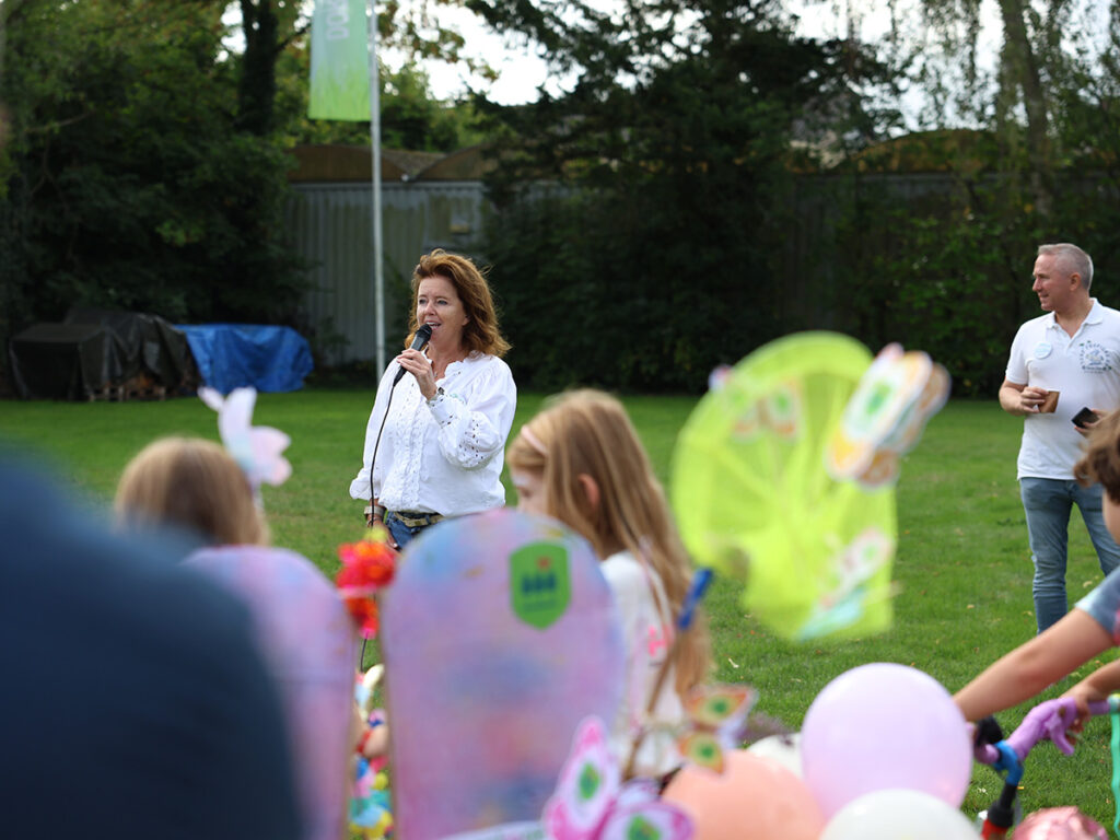 Astrid - voorzitter OVP - spreekt de deelnemers van de De versierde fietsparade toe