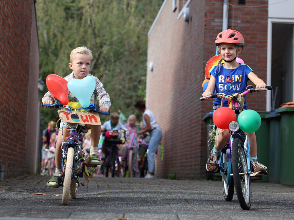 Twee kinderen fietsen weg.