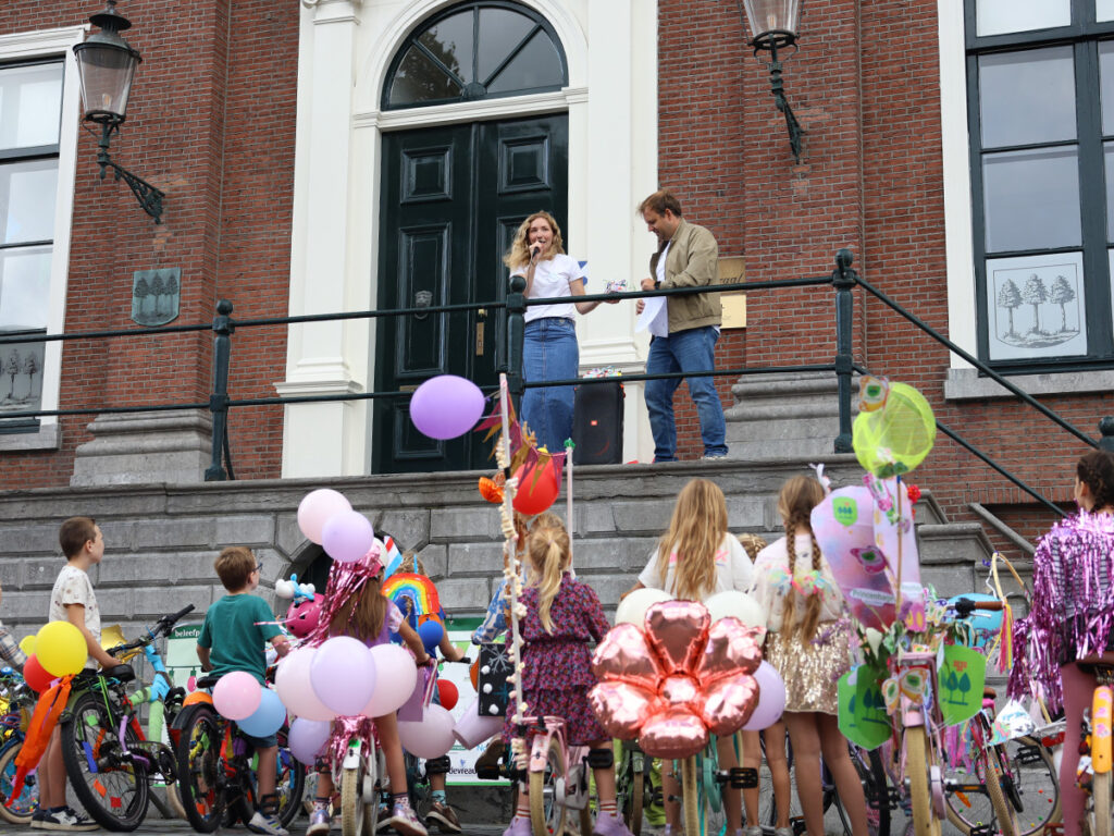 De juryleden spreken de kinderen toe vanaf het bordes van het raadhuis