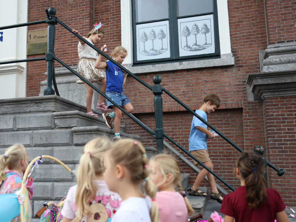 Kinderen lopen de trappen af van het bordes