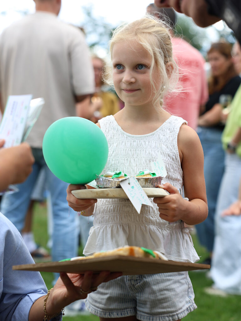 meisje houdt een bord vast met een groene ballon
