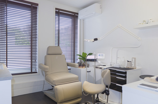 Mooie, steriele praktijkruimte met een behandelstoel en een stoel voor de pedicure